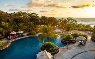 Resort amenity photo of a beach club pool at sunset