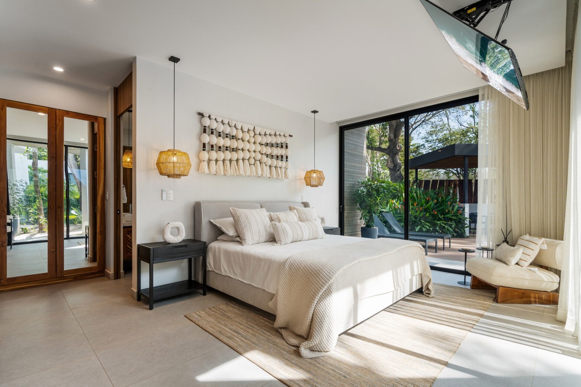 Bedroom with doors open to the garden for air circulation in a Guanacaste home