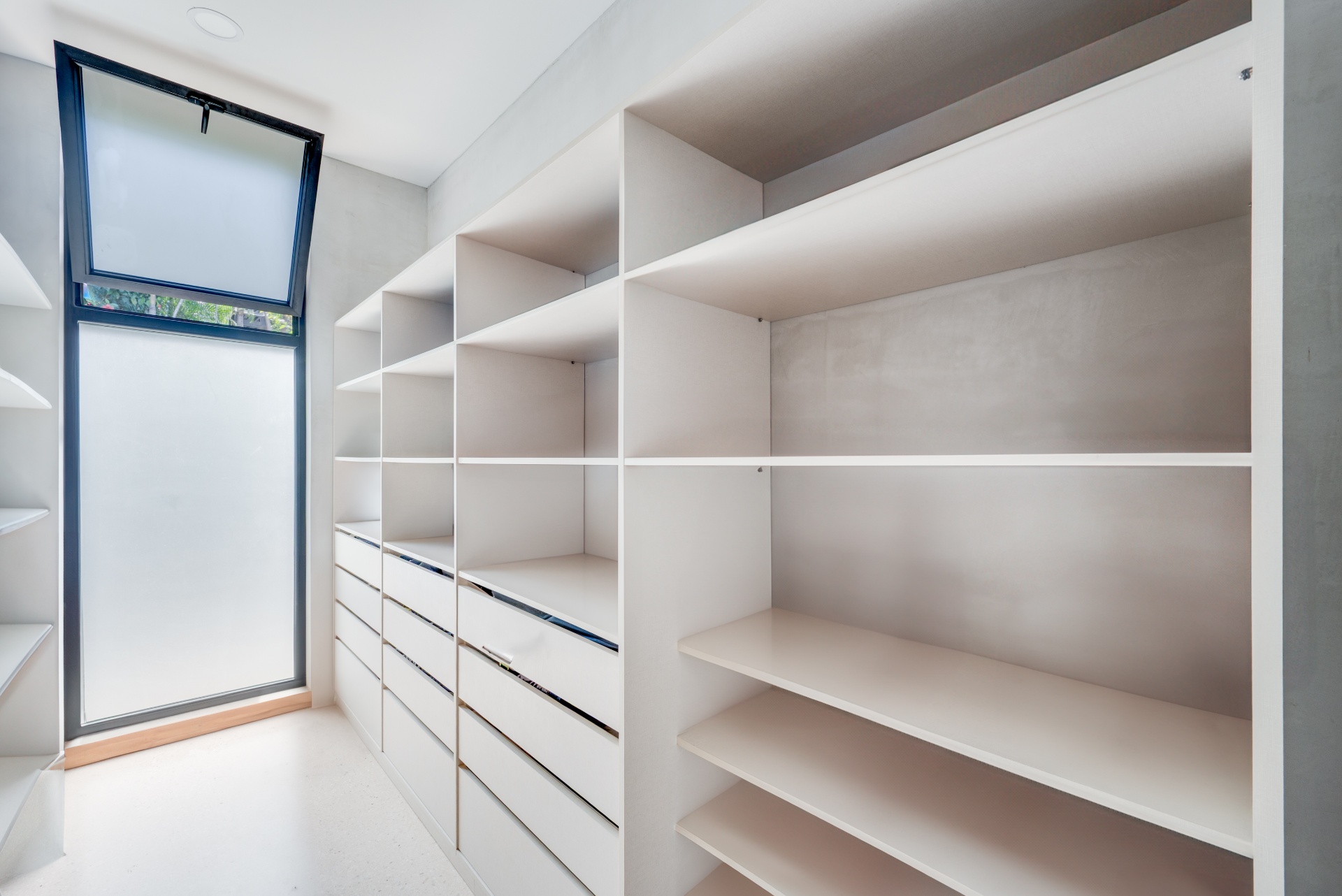 Walk-in closet with open shelving and a window for airflow in a Mar Vista home