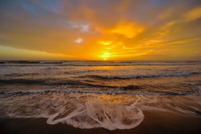 Sunset on Tamarindo Beach with silhouettes near the waterline